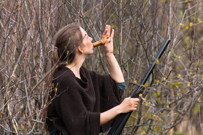 woman-hunter-shrubs-wooden-duck-call | coyote hunting tips