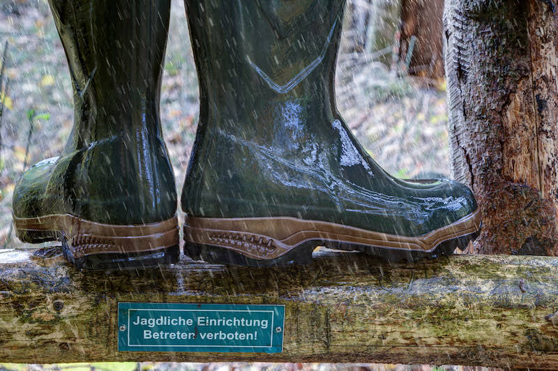 Wellington boots stand in the rain on the wooden ladder of a hunting pulpit | deer hunting checklist excel