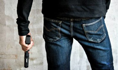 killer-holding-gun-side-him-robbery | Beretta 21A Bobcat | Gun Carrier Handgun Review | Featured