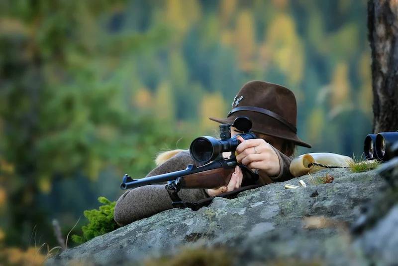 two hunter finaYoung, Clever Woman Deer Hunter wearing green uniform with Rifle | muzzleloader brandsd their shot | What Is A Muzzleloader And Why Should You Use It For Hunting | Featured