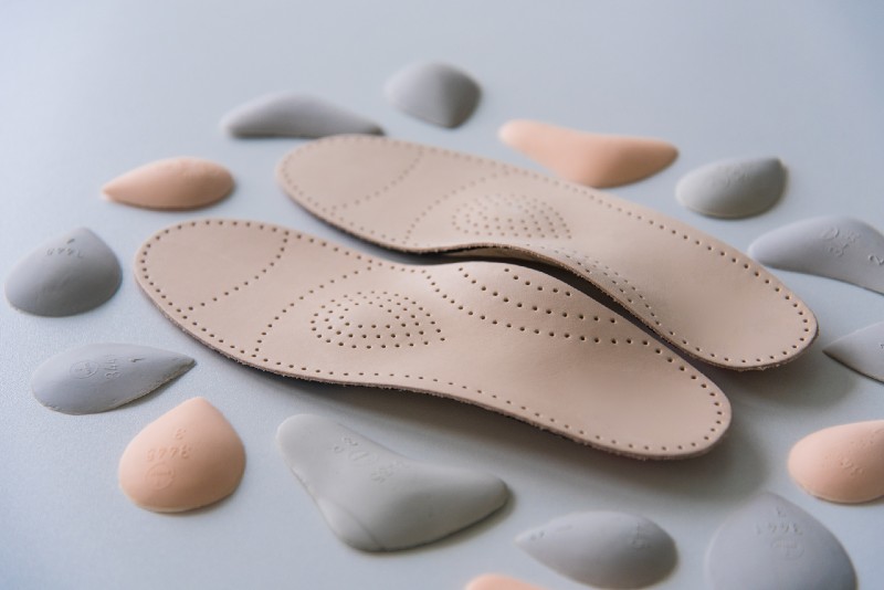 A pair of leather orthopedic insoles surrounded by components-Boot Accessories-ss