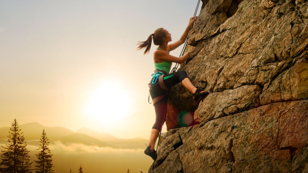 beautiful-woman-climbing-on-high-rock | Women Climbers: Lauren Delaunay Miller's Experience With Rock Climbing [LISTEN] | Featured
