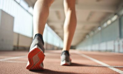 fit runner standing on racetrack in athletics arena | What Is A 6-Minute Mile & How To Do It | Featured