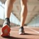 fit runner standing on racetrack in athletics arena | What Is A 6-Minute Mile & How To Do It | Featured