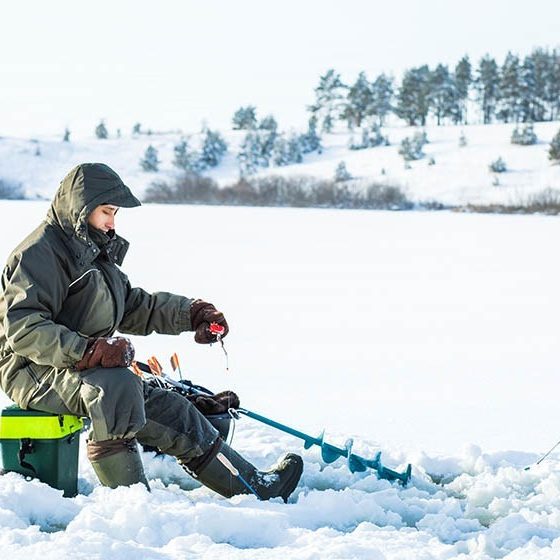 young man fishing hole on ice | Ice Fishing Gear for Beginners | Featured